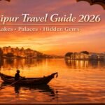 Golden sunset view of Lake Pichola with City Palace and Lake Palace in Udaipur, featuring a traditional Rajasthani boat and reflections in water